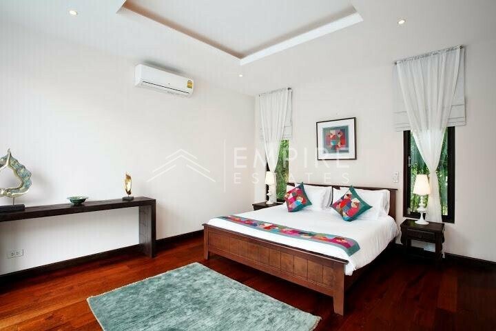 a white room with wooden floors and large windows