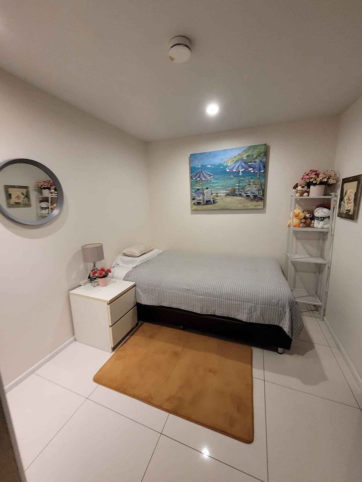 a room with a bed, desk, and picture on the wall