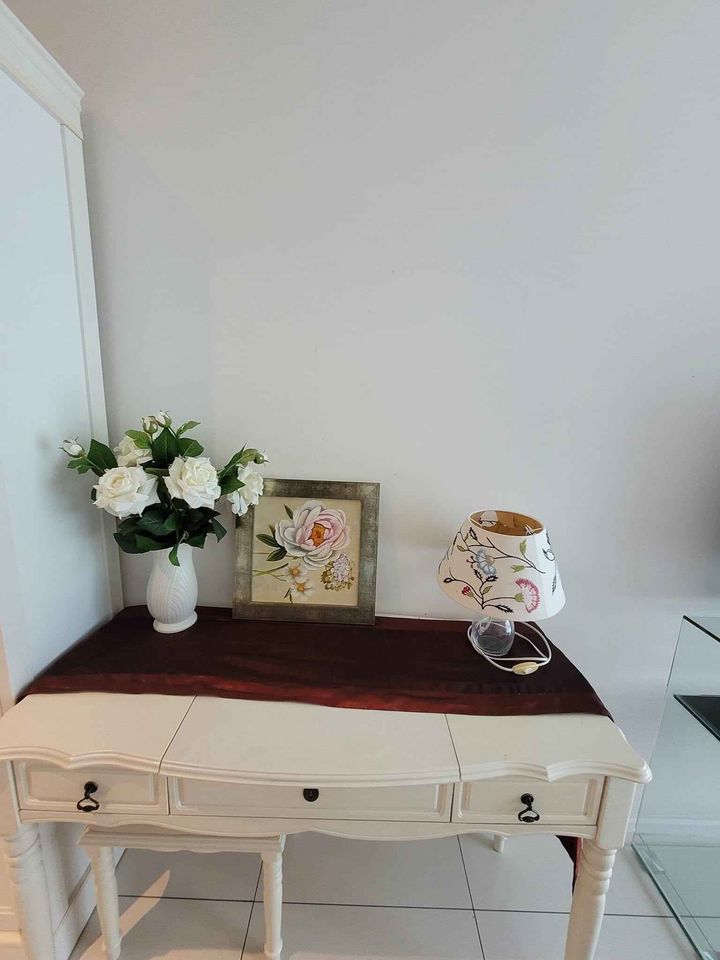 an ornate console with two vases and white flowers