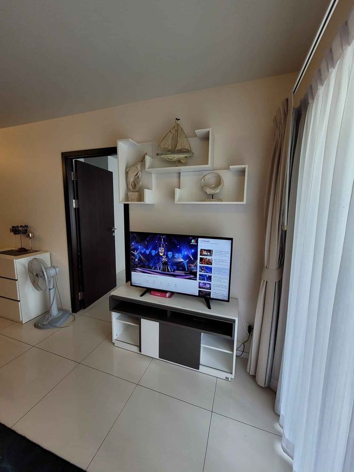 a living room with white tile flooring and a white flat screen tv